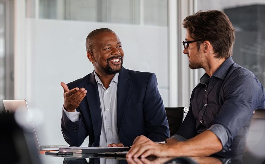 Two professionals speaking at a conference table.