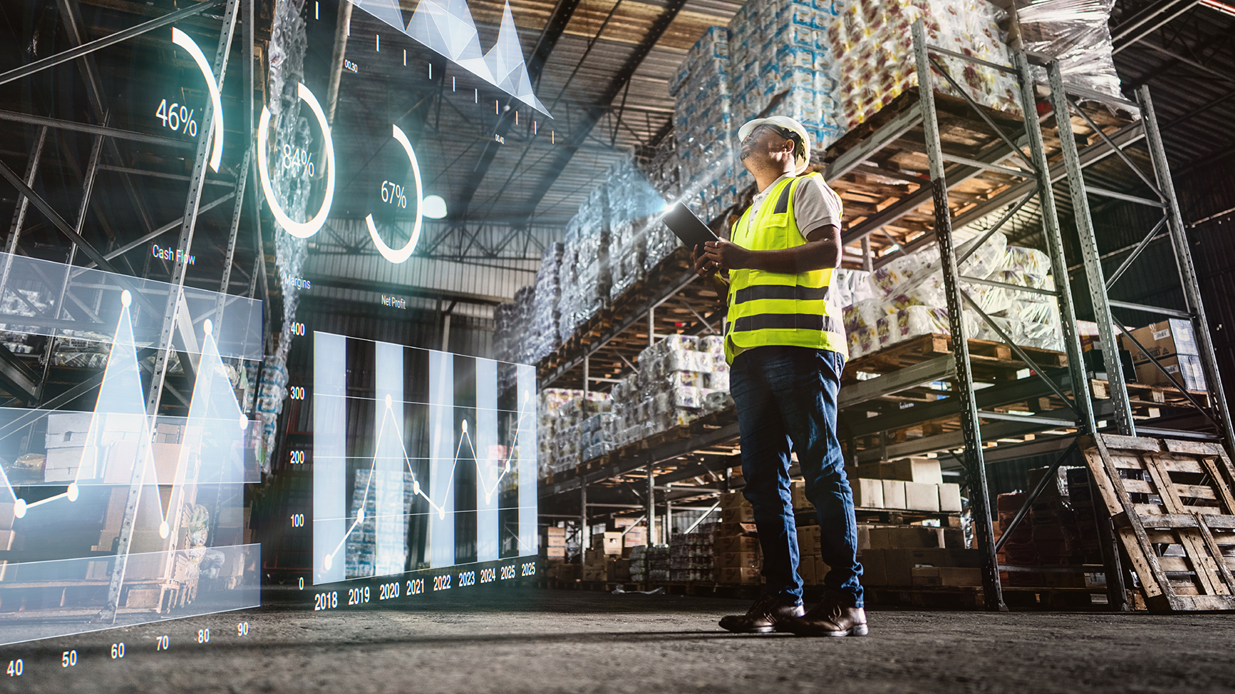 A warehouse worker wearing a hard hat and a safety vest holding an electronic tablet. An overlay shows metrics being displayed on the tablet as an augmented reality hologram.