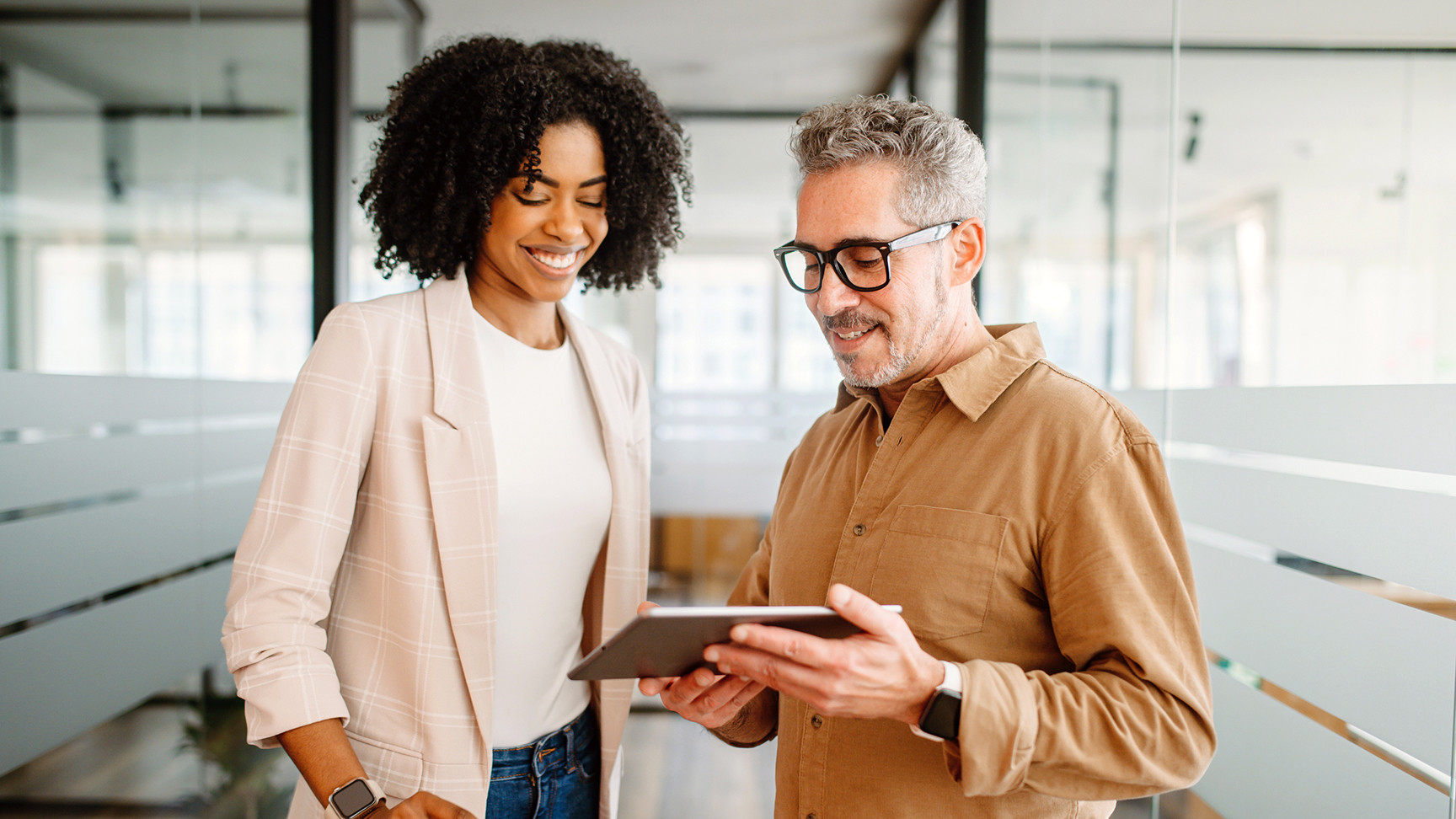 A man and woman staring at an electronic tablet